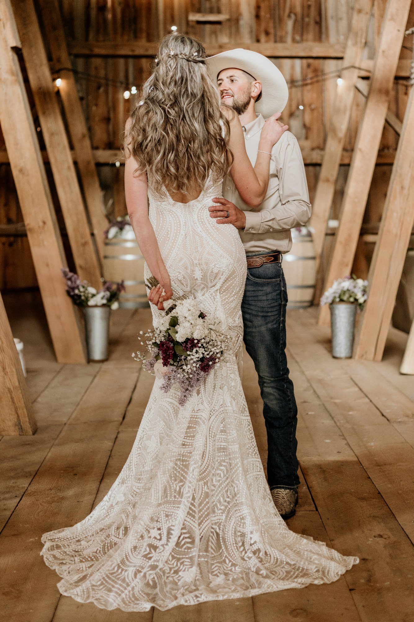 Bride and groom embracing inside a timber barn