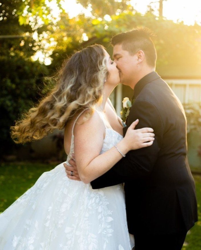 Groom dipping his bride for a kiss in golden backlight