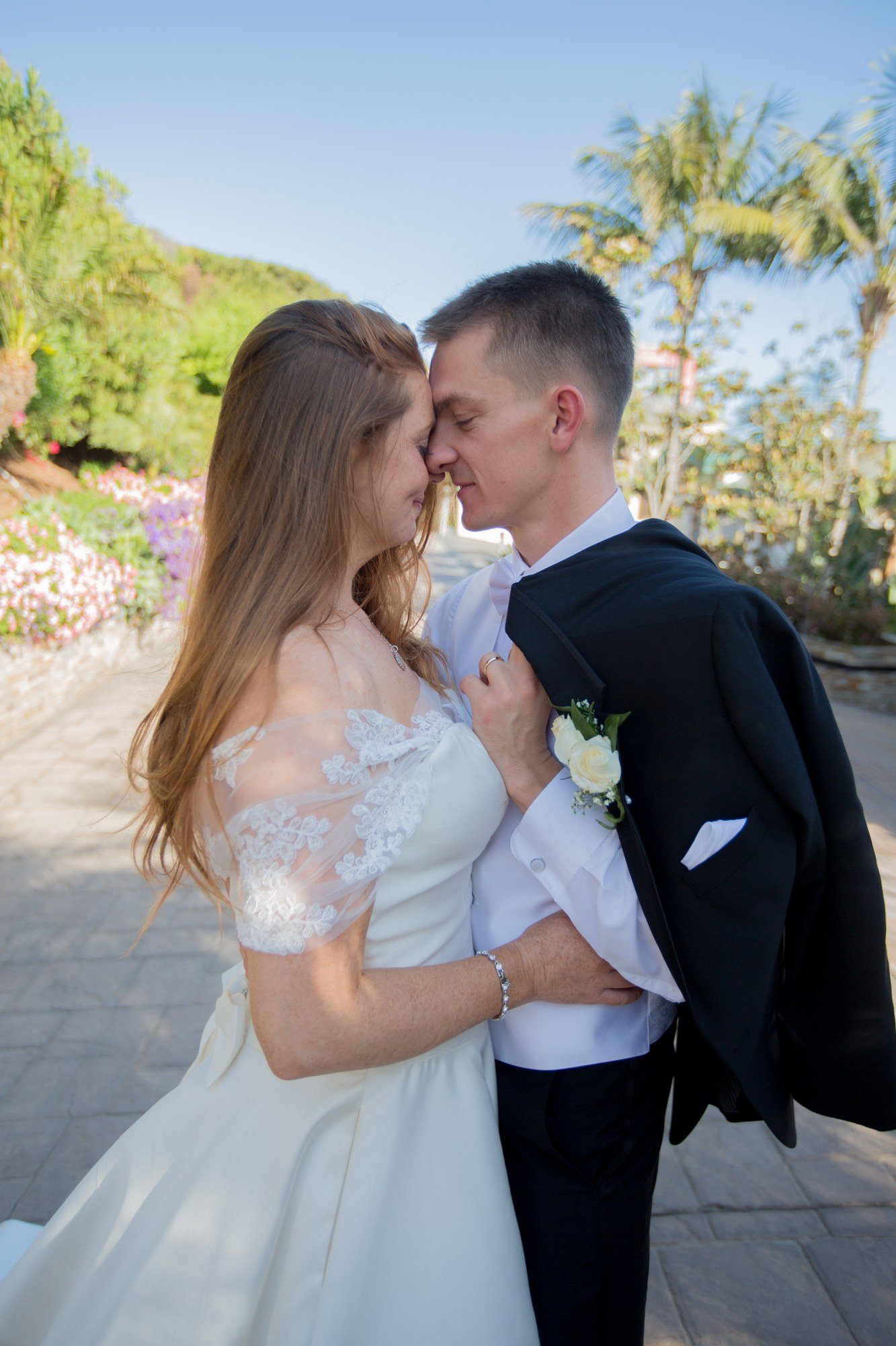 Bride and groom nose to nose among coastal gardens