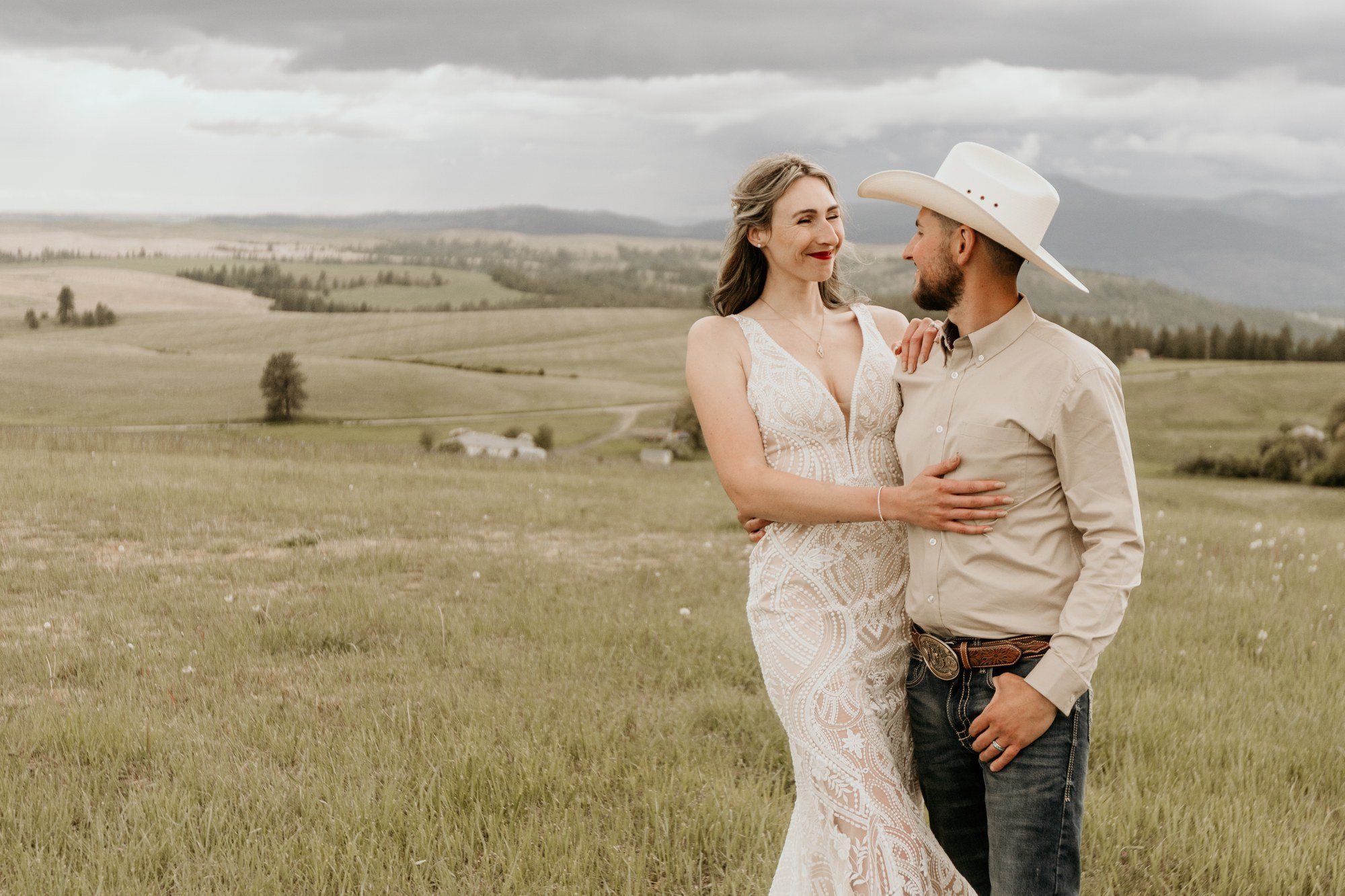 Couple embracing in a high meadow with mountains behind