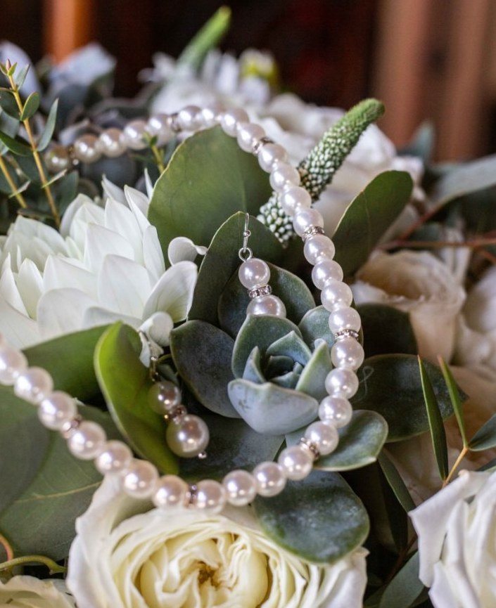 Close-up of pearls draped over a succulent in the bridal bouquet