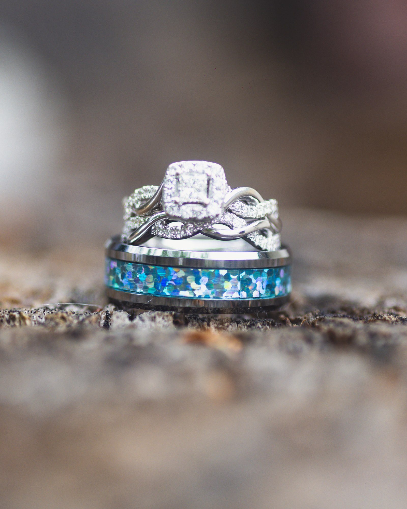 Engagement ring and opal wedding band on weathered wood