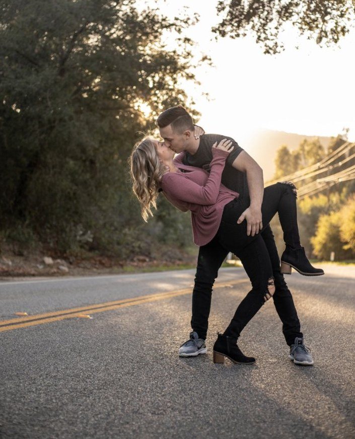 Couple embracing on an empty country road at sunset